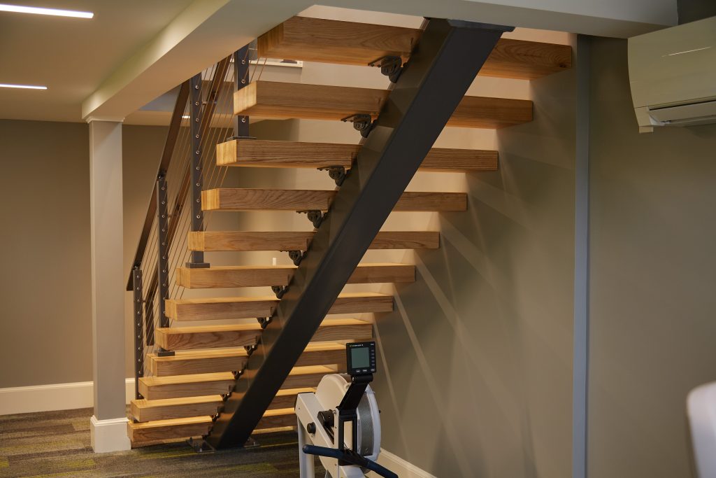 Floating Stair Stringer with Black Powder Coat and Red Oak Treads Seen From Behind