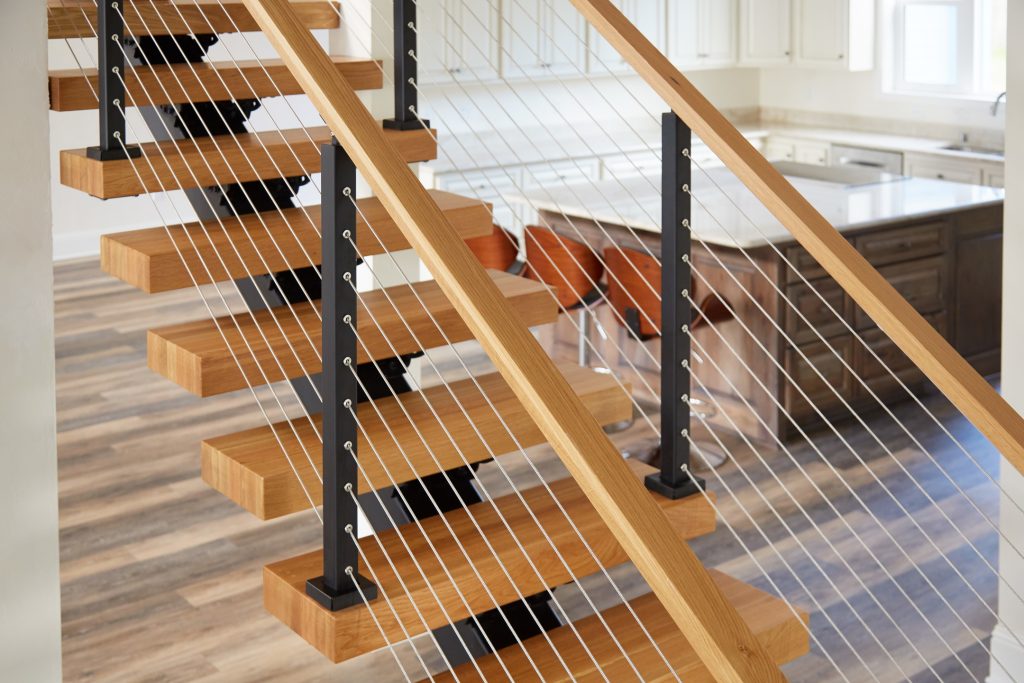 Cable Railing on Floating Stairs featuring White Oak Handrail & Black Powder Coated Posts