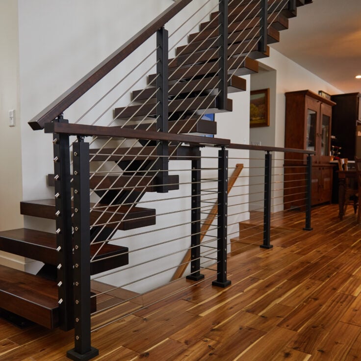 Floating stairs featuring hard maple treads with rod railing and a rod railing guard rail.