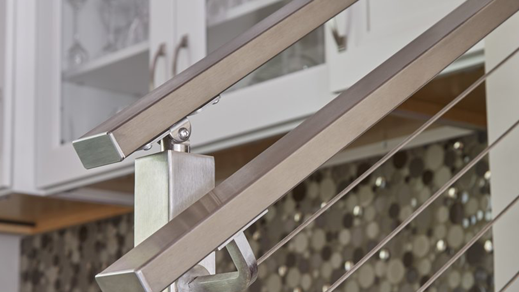 Sleek, stainless steel handrail connected to stainless steel cable railing system