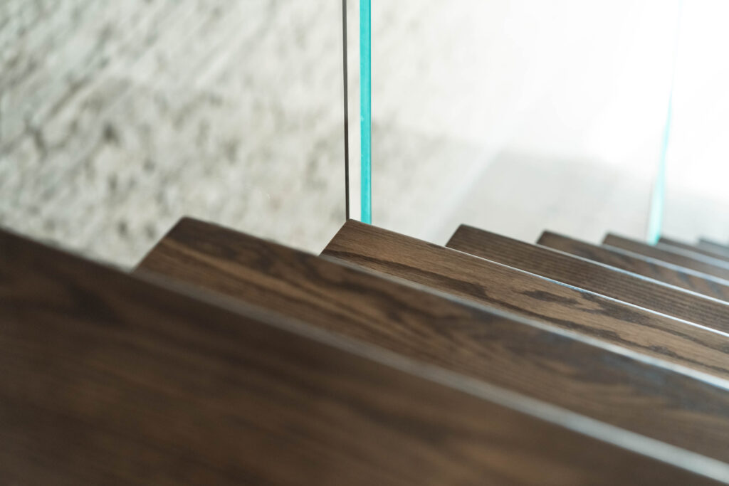 Dark Stained Wooden Stair Treads with Glass Railing