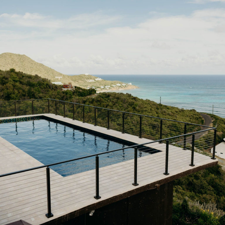 Viewrail Signature Cable Railing surrounds a large pool which overlooks the ocean in the Virgin Islands.